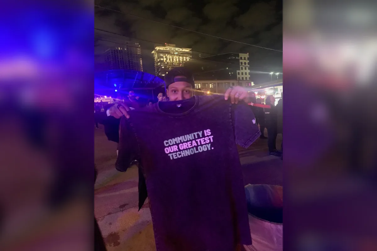 Kris holding the "community is the greatest technology" shirt